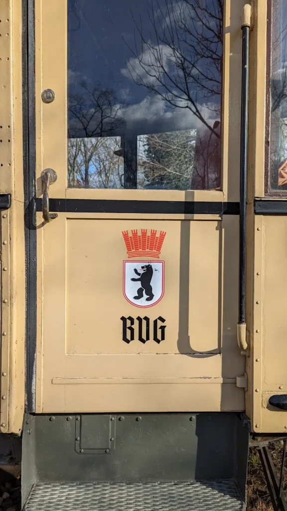 Beige Wagentür eines historischen Straßenbahnwagens mit Berliner Wappen und BVG-Schriftzug an der Machnower Schleuse