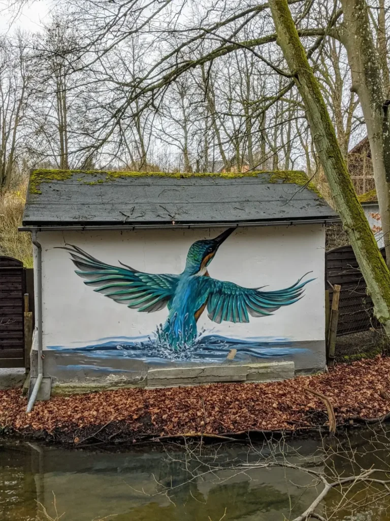 Wandbild mit Eisvogel an einer Hauswand in Buckow