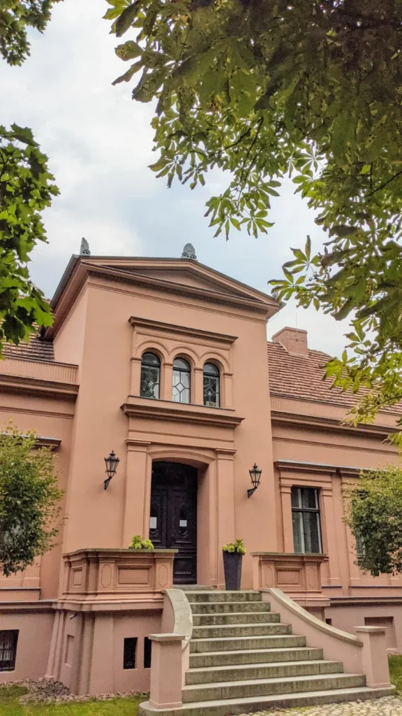 Rosafarbenes Gutshaus mit Freitreppe und Rundbogenfenstern am Hultschiner Damm in Mahlsdorf