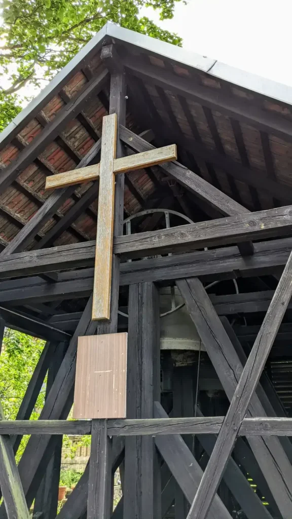 Hölzerner Glockenstuhl mit Kreuz auf dem alten Kirchhof an der Dorfstraße in Malchow