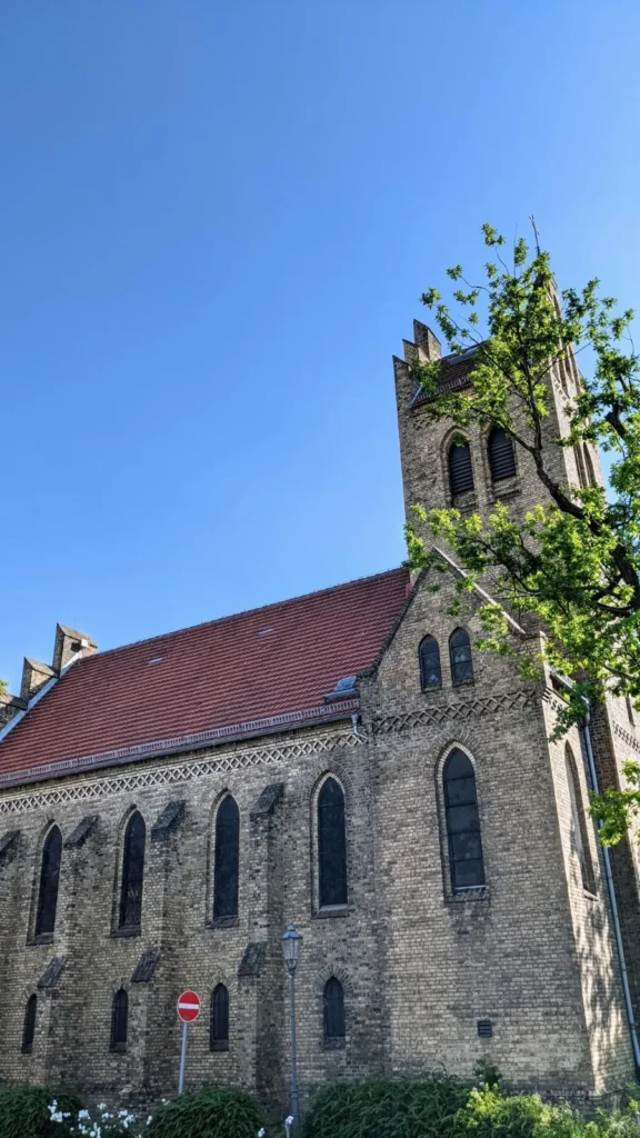 Neugotische Backsteinkirche mit Turm und rotem Dach am Dorfanger Alt-Marzahn