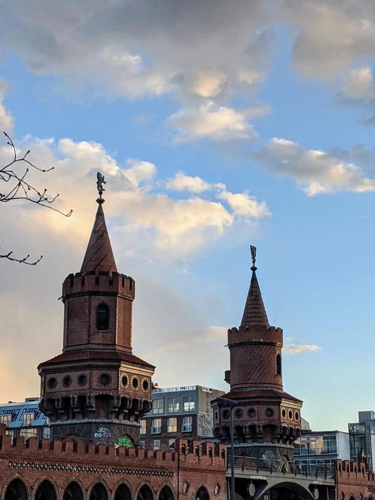 Die beiden Backsteintürme der Oberbaumbrücke im Abendlicht vor einem Wolkenhimmel