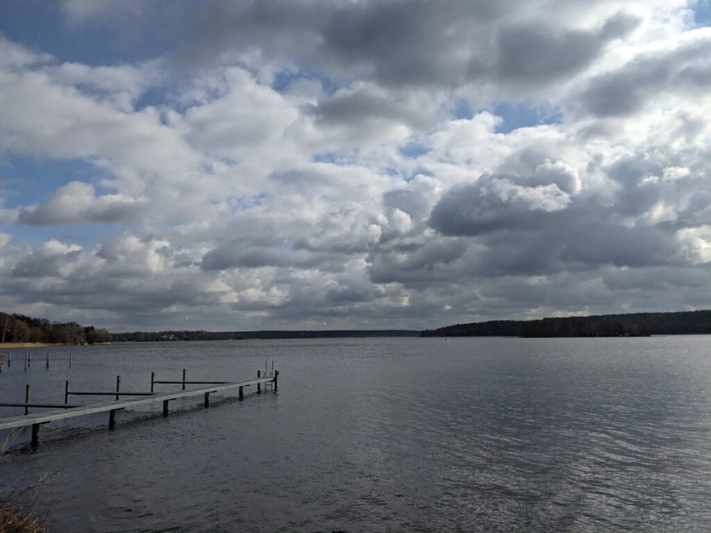 Weite Wasserfläche der Havel unter dichten Wolken, links ein leerer Bootssteg
