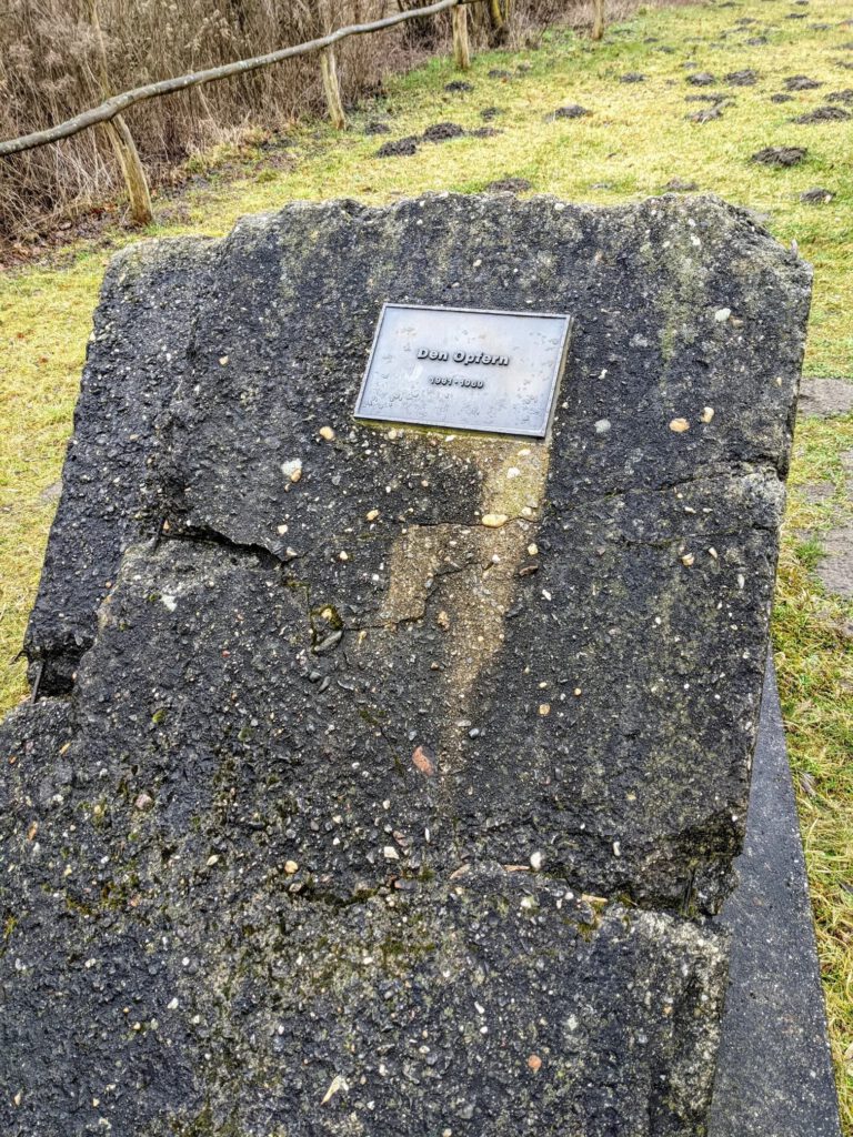 Bruchstück einer Betonmauer mit einer kleinen Metalltafel, auf der „Den Opfern 1961–1989“ steht