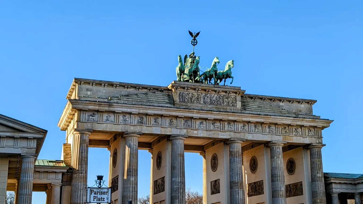 Brandenburger Tor mit seinen Säulen und der Quadriga obenauf vor wolkenlosem blauem Himmel