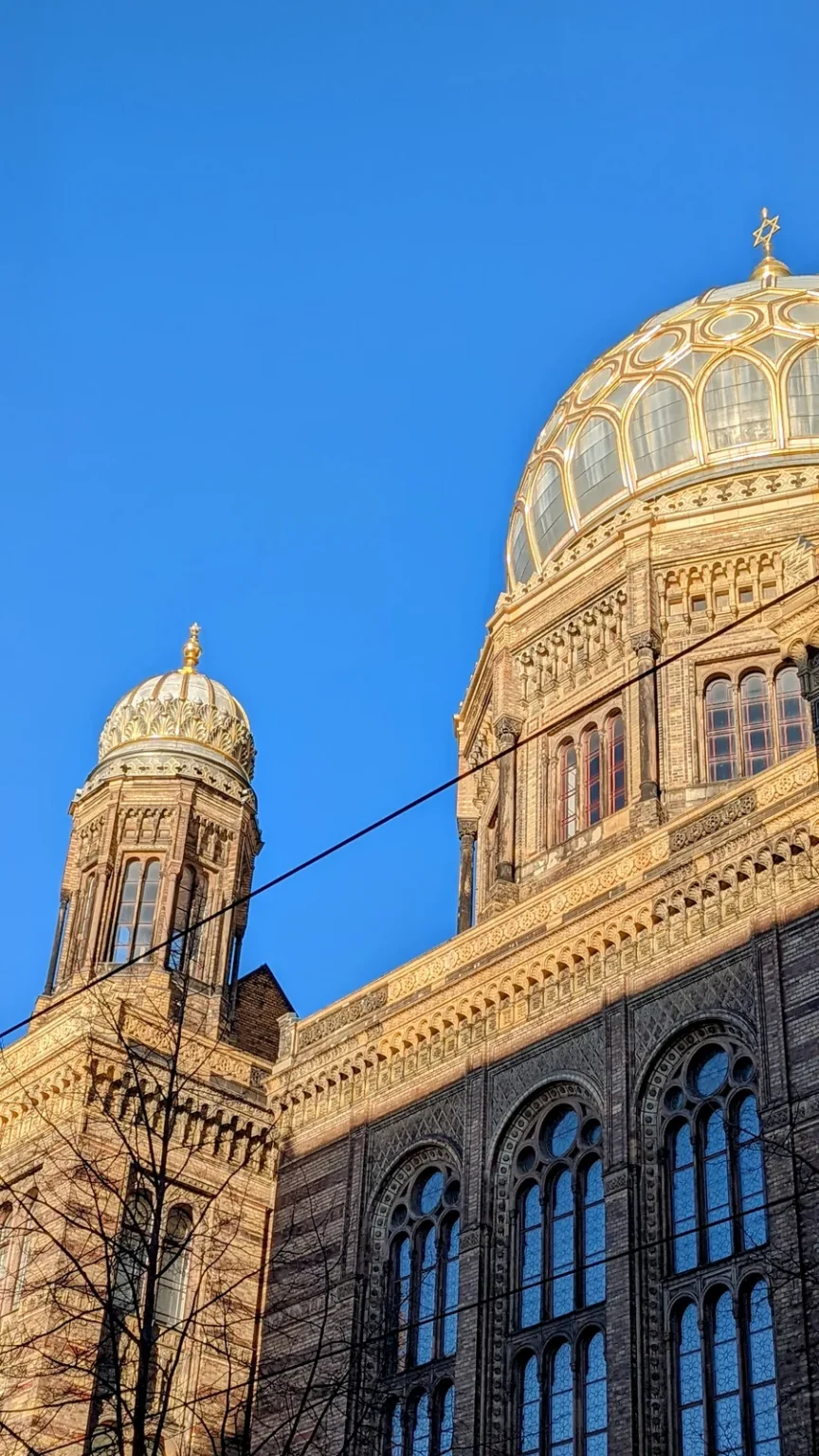 Goldene Kuppel und Fassade der Neuen Synagoge an der Oranienburger Straße vor blauem Himmel