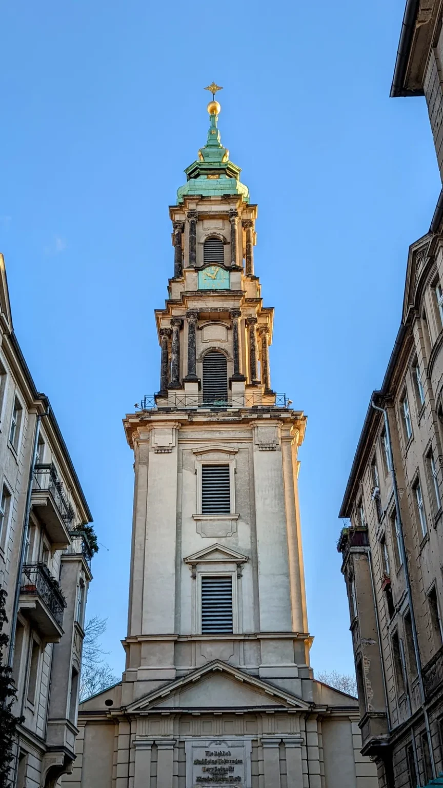 Barocker Turm der Sophienkirche in der Spandauer Vorstadt zwischen zwei Häuserzeilen, grüne Turmspitze