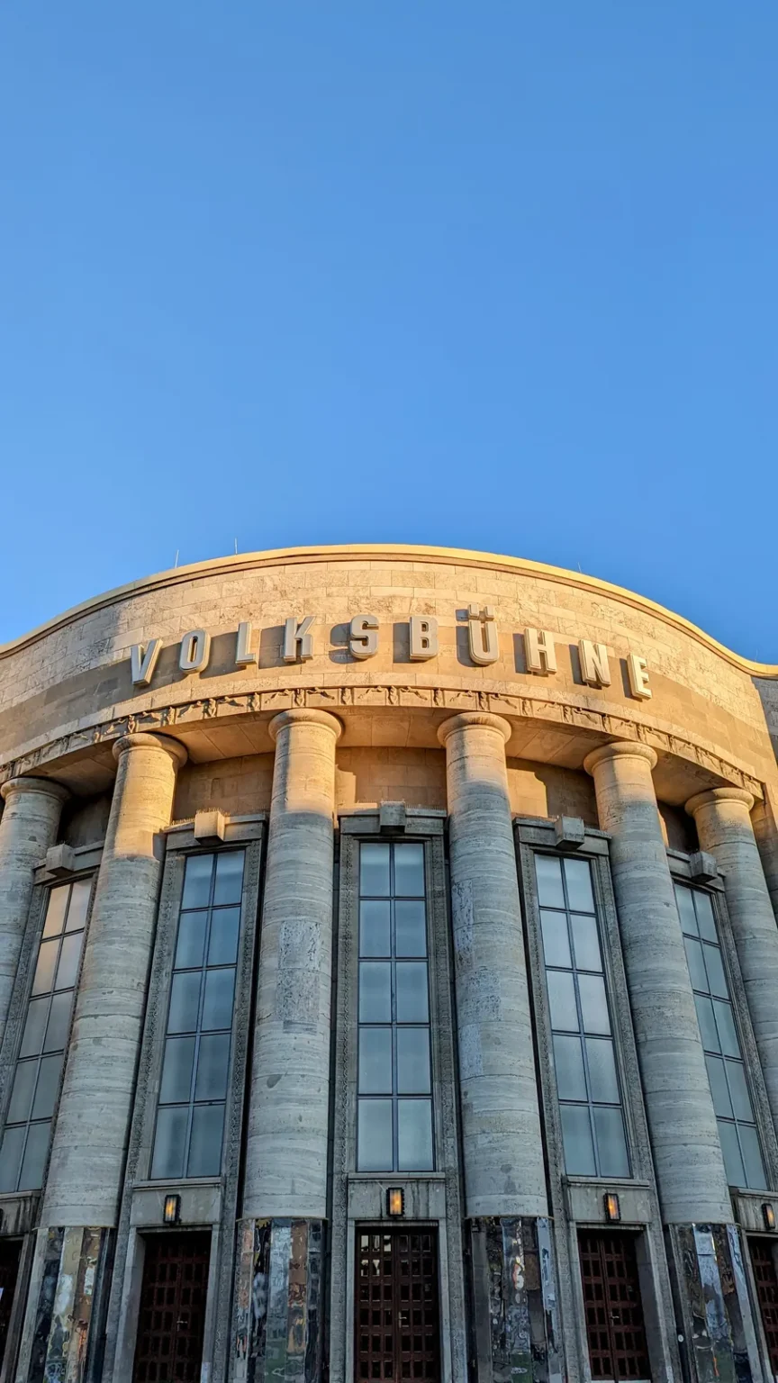 Gerundete Fassade der Volksbühne am Rosa-Luxemburg-Platz mit hohen Pfeilern und Schriftzug über dem Eingang