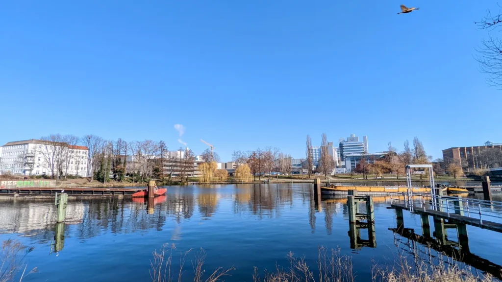 Ruhiges Wasser am Kanal im Norden von Moabit mit Steg, Booten und Bäumen am Ufer