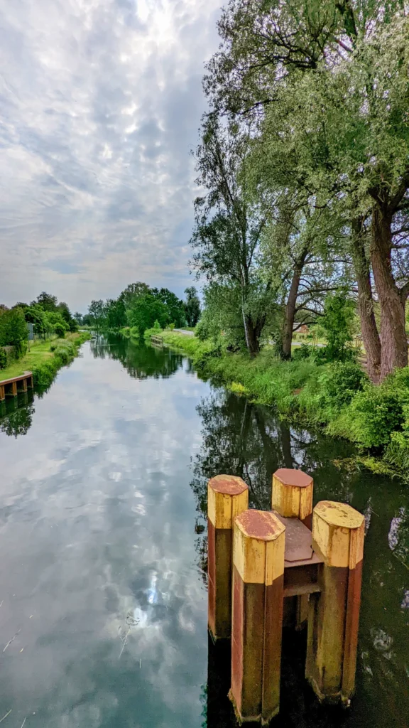 Finowkanal in Niederfinow mit hölzernen Dalben im Vordergrund, am rechten Ufer alte Weiden