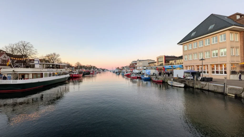 Alter Strom in Warnemünde mit Ausflugsschiff, Fischerbooten und Häusern am Ufer