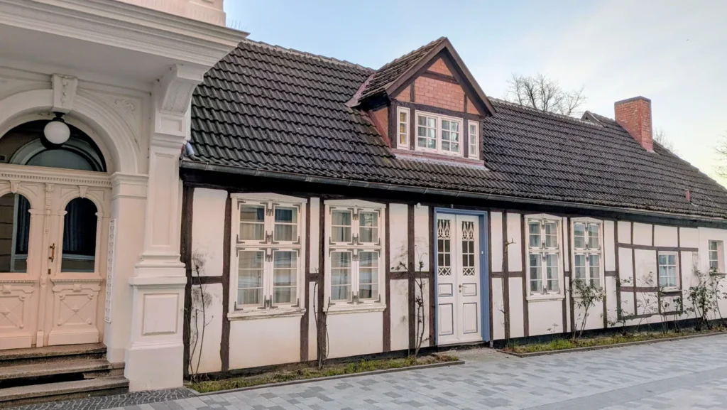 Kleines Fachwerkhaus mit Dachgaube und blauer Tür in Warnemünde