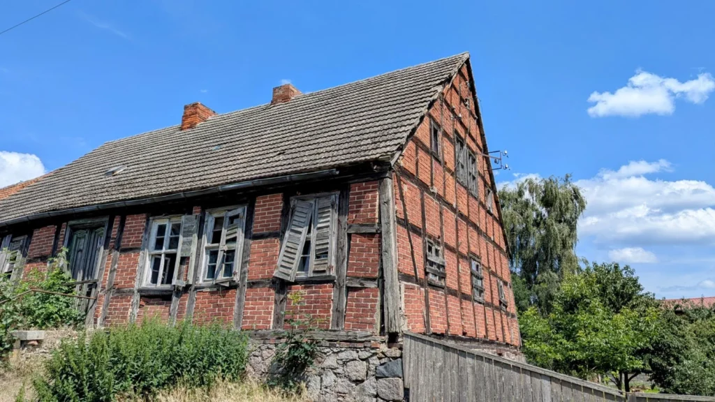 Altes Fachwerkhaus mit Backsteingefachen, Feldsteinsockel und verwitterten Fensterläden in Neuküstrinchen