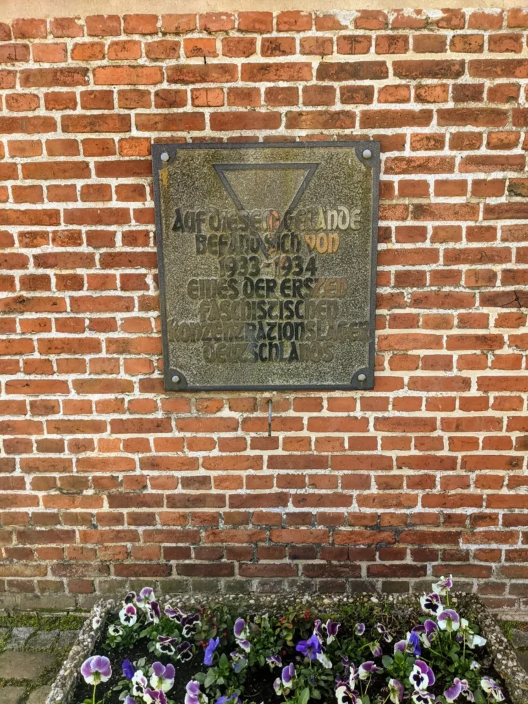 Gedenktafel für das frühe KZ Oranienburg an einer Backsteinmauer in der Berliner Straße