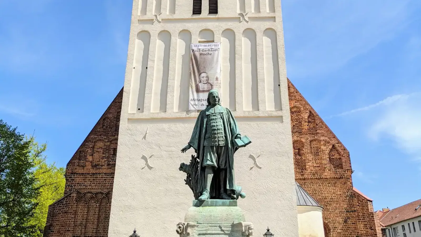 Turm der Paul-Gerhardt-Kirche in Lübben mit dem Denkmal davor
