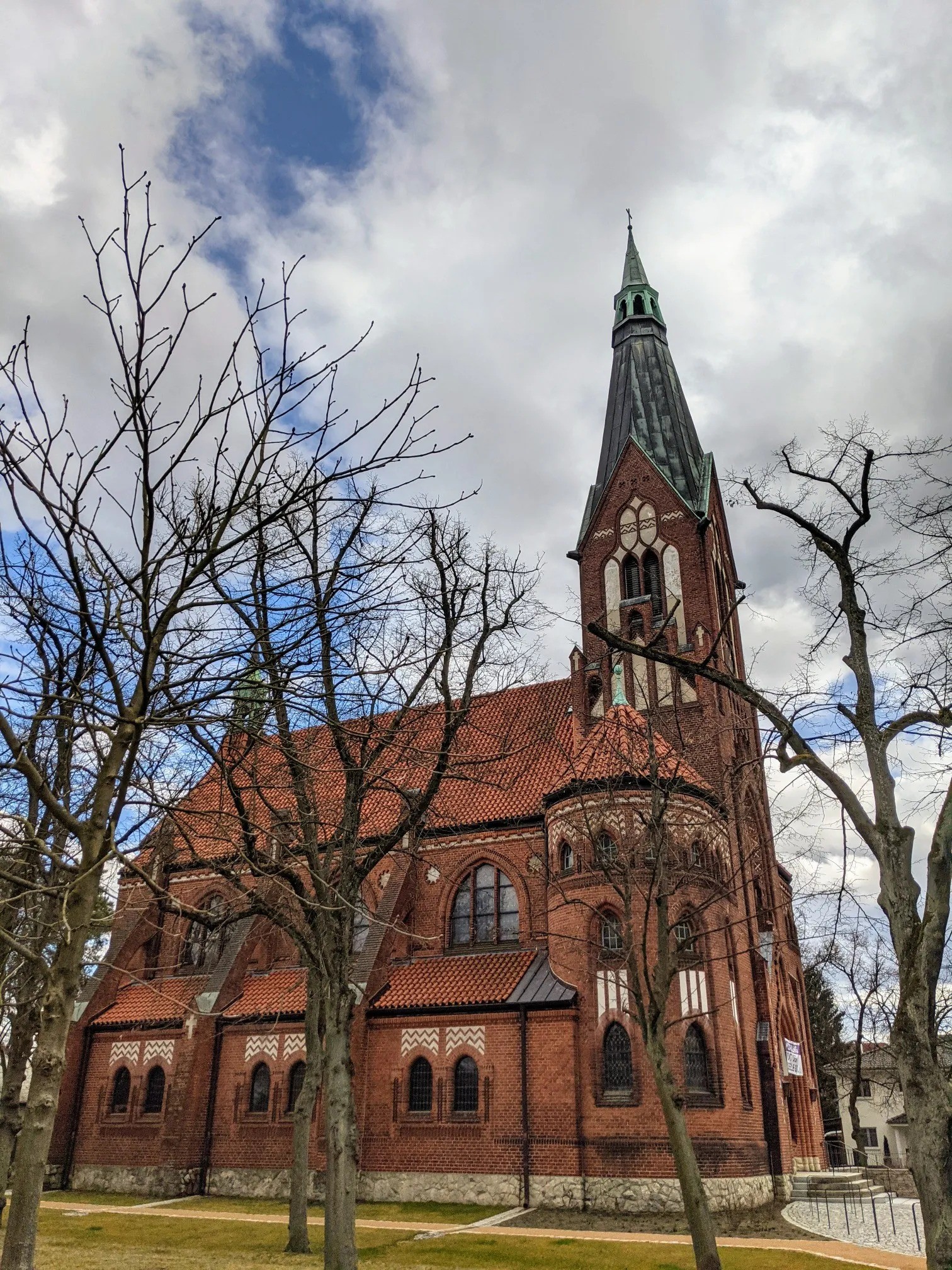 Rote Backsteinkirche mit hohem, schlankem Turm