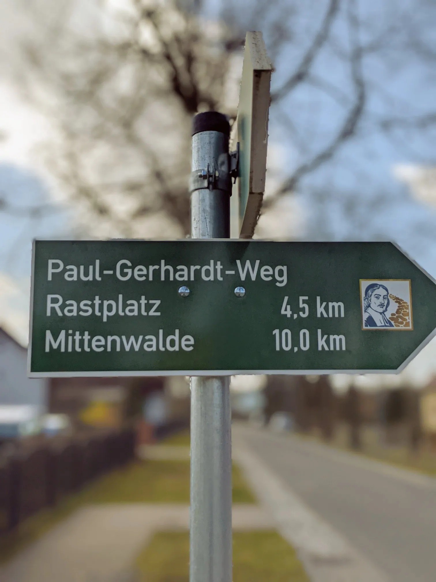 Grünes Wegweiserschild Paul-Gerhardt-Weg: Rastplatz 4,5 Kilometer, Mittenwalde 10,0 Kilometer