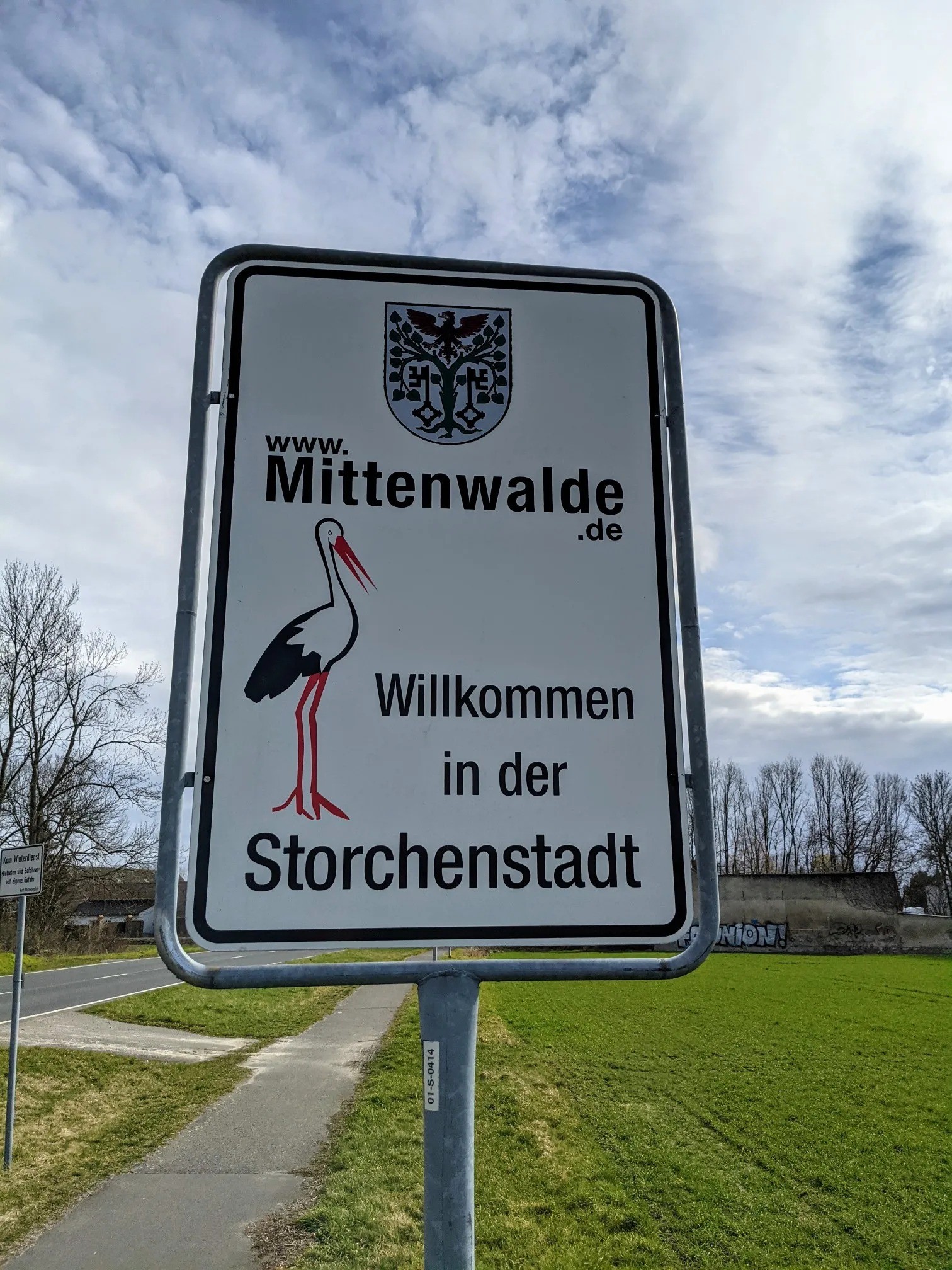 Ortseingangsschild mit Wappen und Storch und der Aufschrift Willkommen in der Storchenstadt