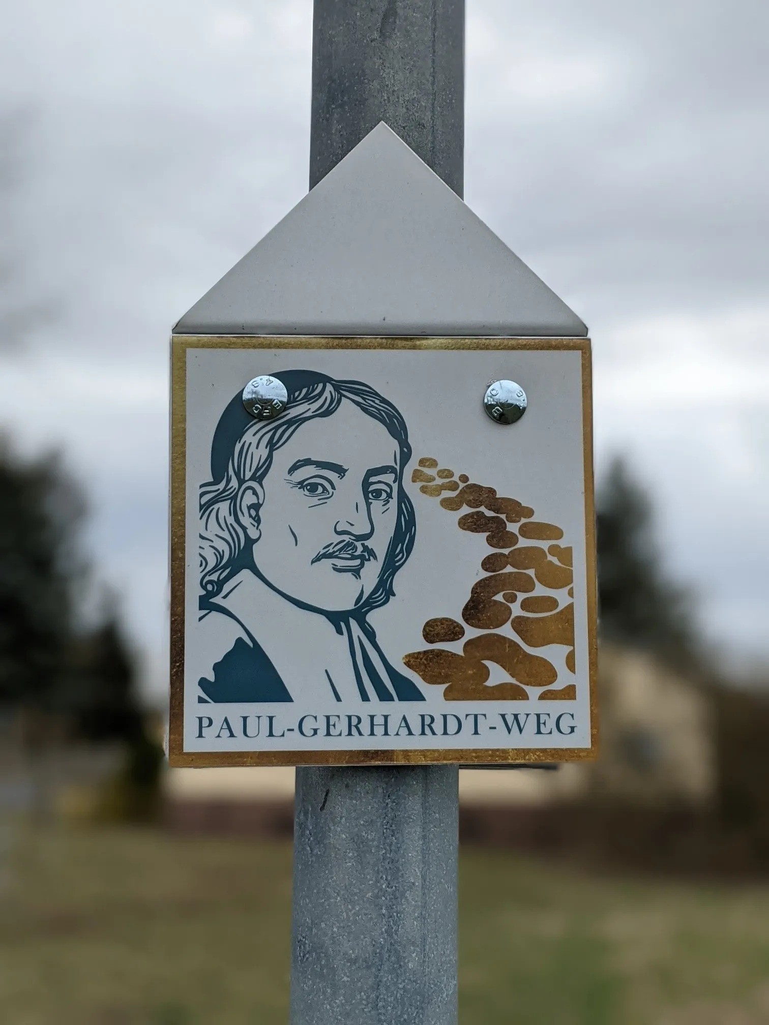Wegzeichen mit Porträt und der Aufschrift „Paul-Gerhardt-Weg“