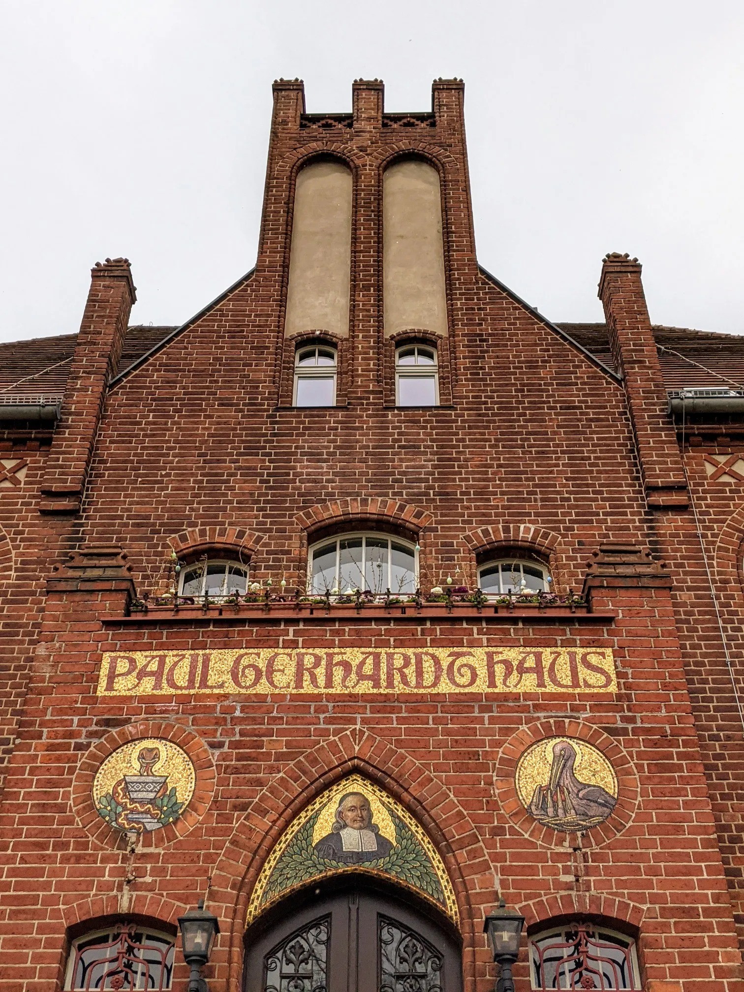 Portal mit Mosaikbildern und dem Schriftzug „Paul Gerhardt Haus“
