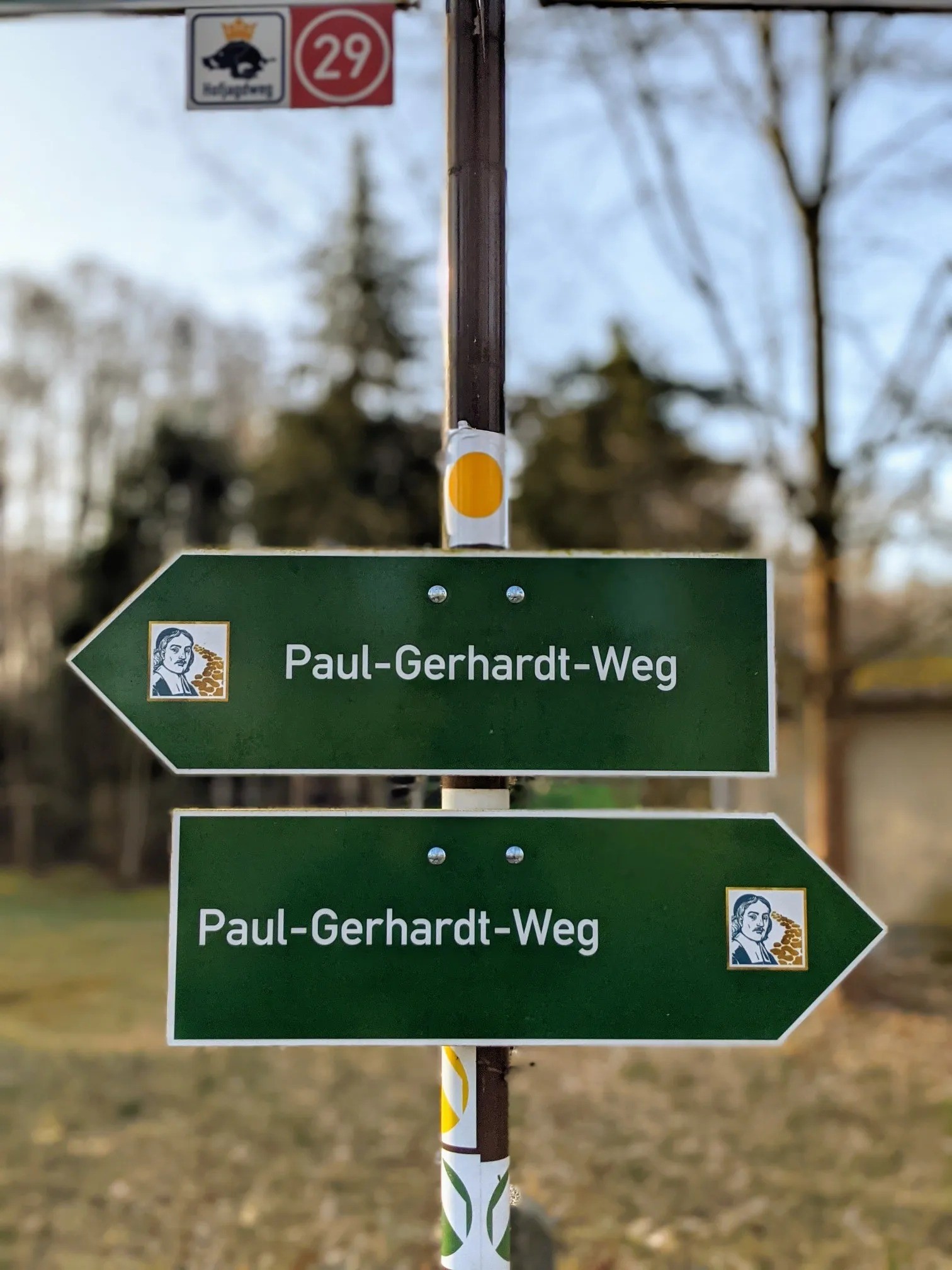 Zwei grüne Wegweiser „Paul-Gerhardt-Weg“ an einem Mast