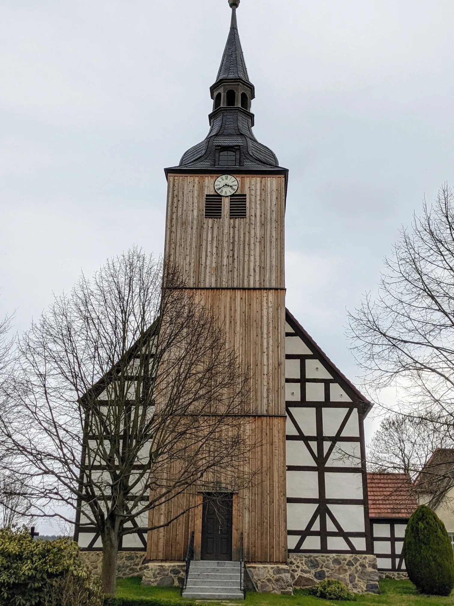 Fachwerkkirche mit Holzturm und Uhr
