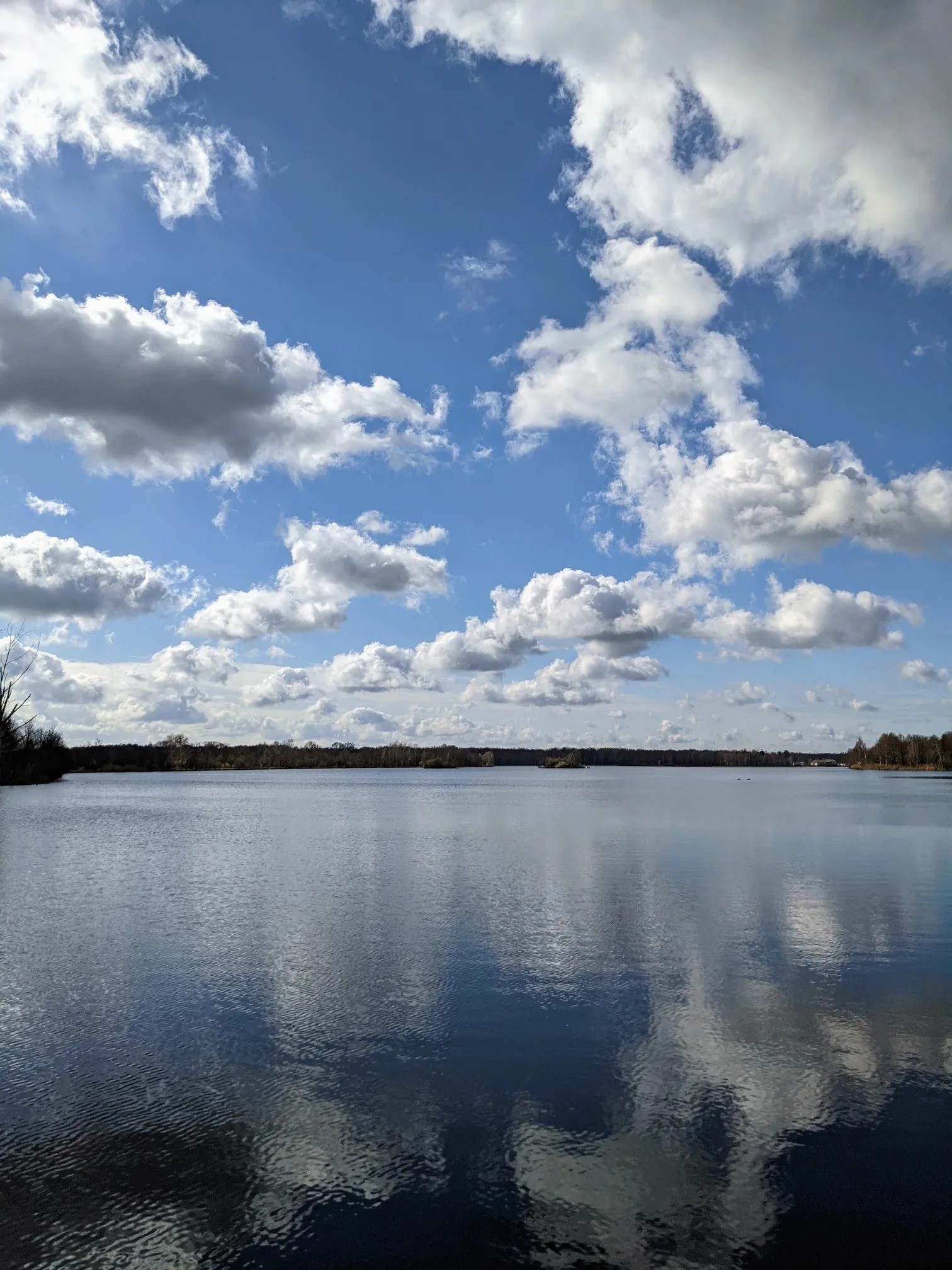 Weiter See mit Wolkenspiegelung