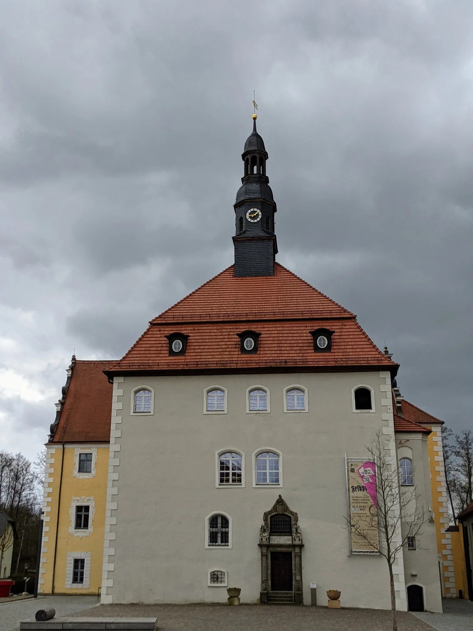 Weiß verputztes Schloss mit rotem Dach und Turm
