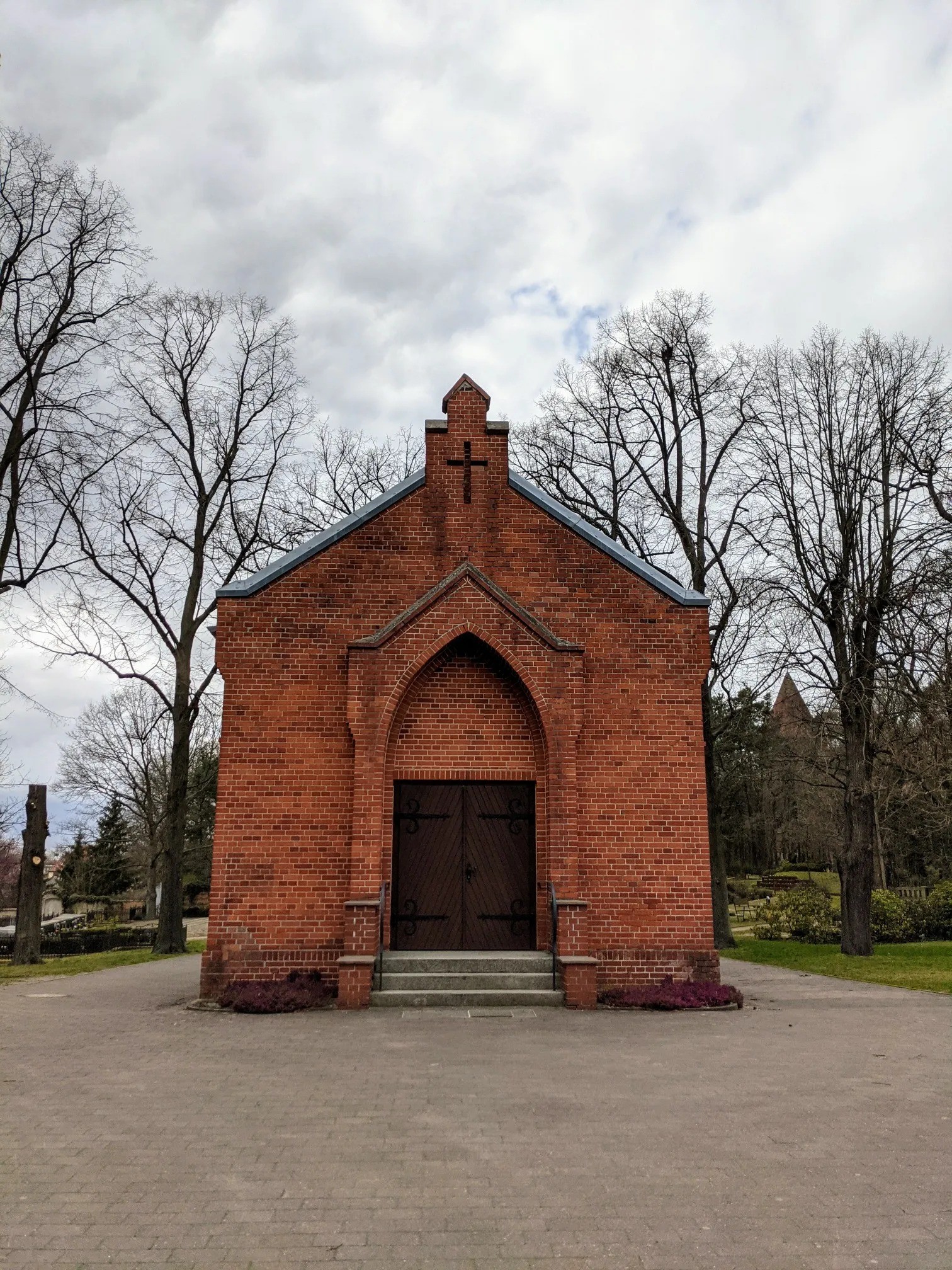 Rote Backsteinkapelle mit Spitzbogenportal