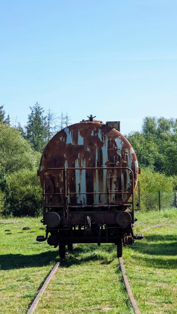 Rostiger Kesselwagen auf einem Gleisstück im Gras