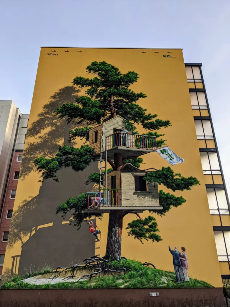 Wandbild an einem Plattenbau in Potsdam mit einem Baumhaus