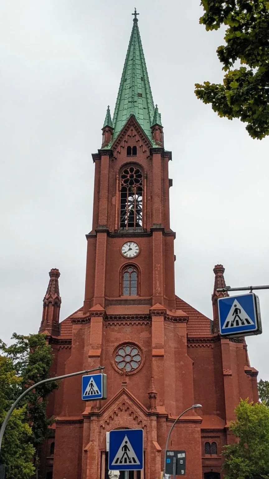Gethsemanekirche an der Stargarder Straße in Prenzlauer Berg, roter Backsteinturm mit grünem Spitzdach