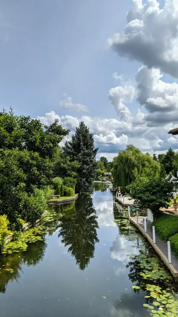 Schmaler Kanal mit Booten und grünen Ufern in der Wassersiedlung Neu-Venedig in Rahnsdorf
