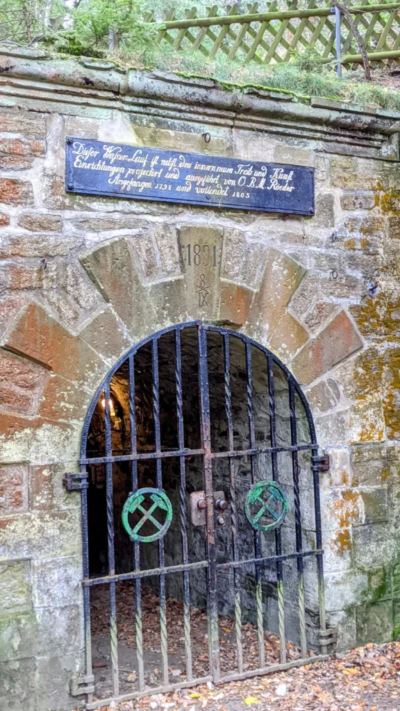 Mundloch des Roeder-Stollens am Rammelsberg mit Gitter, Schlägel-und-Eisen-Zeichen und Inschriftentafel
