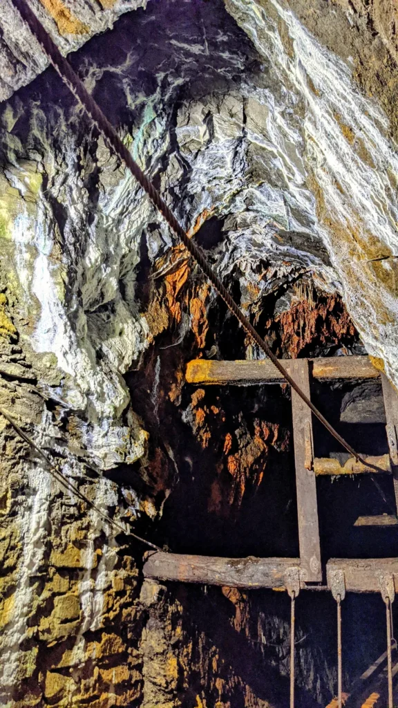 Felswand mit Holzeinbauten und Leiter im Besucherbergwerk Rammelsberg