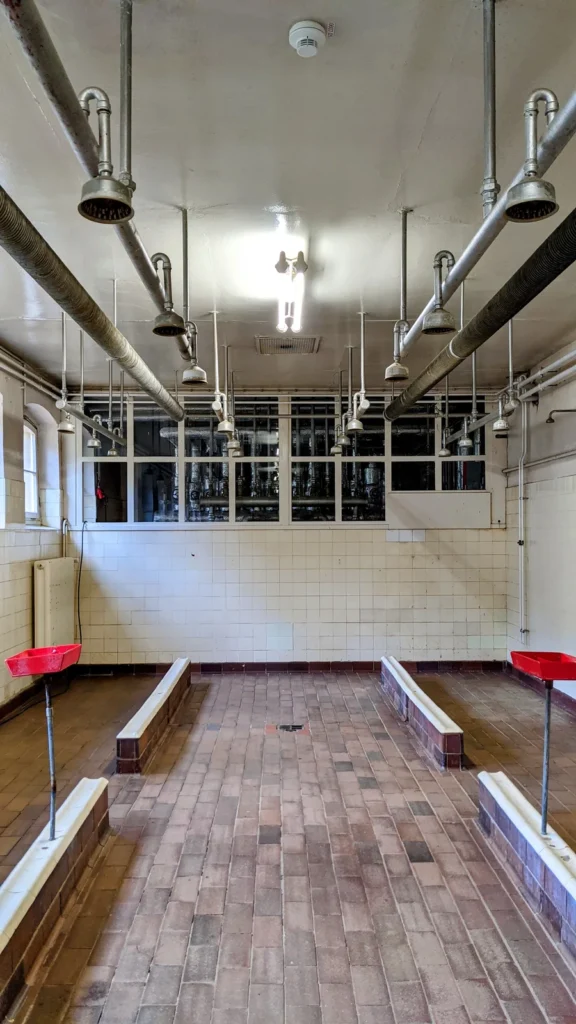 Waschkaue im Rammelsberg mit gekachelten Wänden und Duschrohren unter der Decke