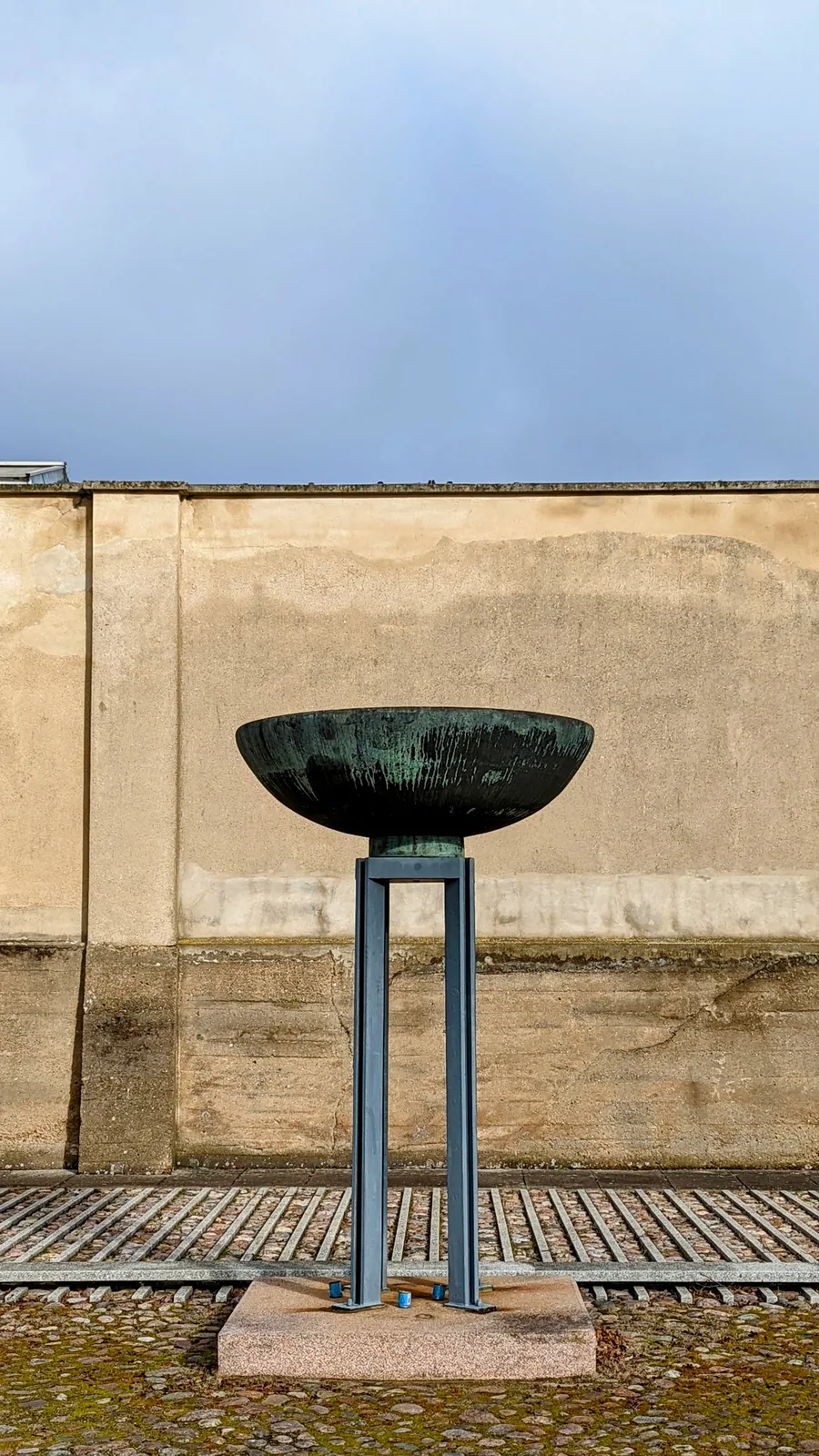 Feuerschale vor einer Mauer in der Gedenkstätte Ravensbrück
