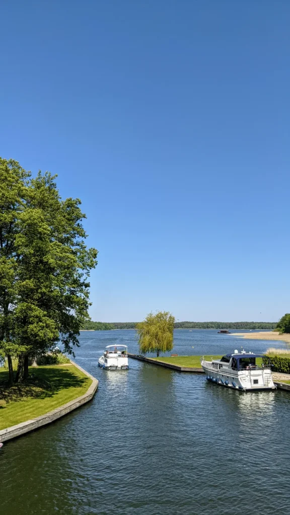 Hafeneinfahrt mit Motorbooten im Hafendorf am Rheinsberger See