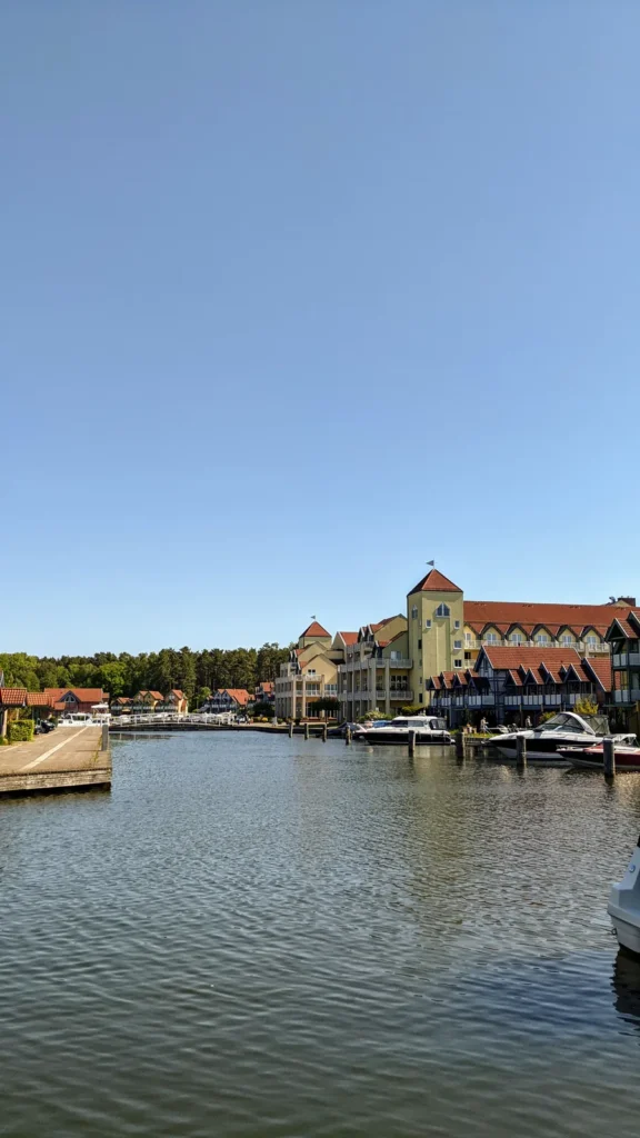 Hafenbecken im Hafendorf am Rheinsberger See mit Ferienhäusern am Ufer