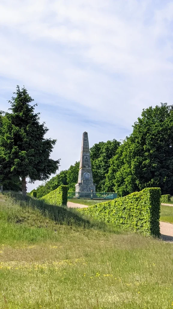 Obelisk im Park von Schloss Rheinsberg zwischen Hecken