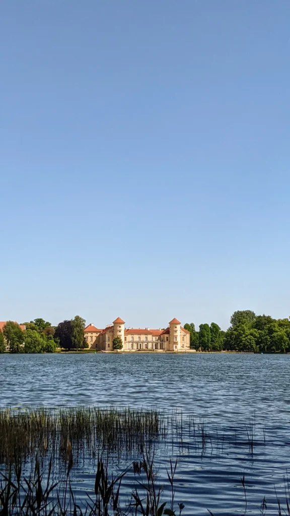 Schloss Rheinsberg am gegenüberliegenden Seeufer hinter Schilf