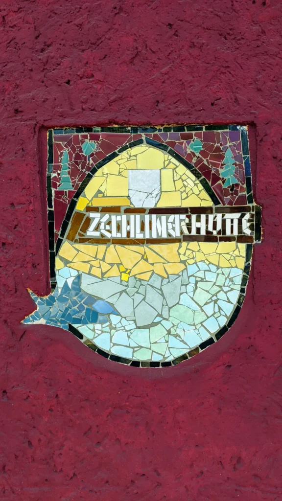 Mosaik mit der Aufschrift Zechlinerhütte an einer roten Hauswand