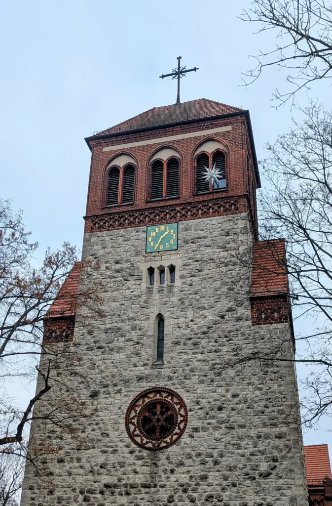Turm der Dorfkirche Rosenthal mit Feldsteinsockel, Backstein-Glockengeschoss, Uhr und Stern vor winterlichem Himmel