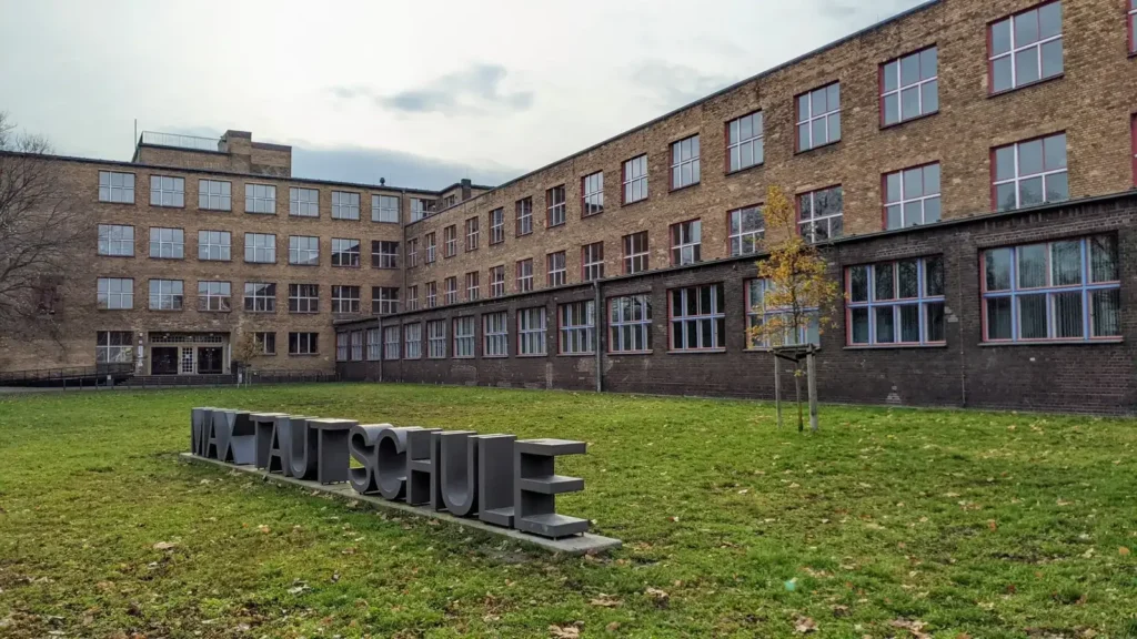 Langer Backsteinbau der Max-Taut-Schule an der Fischerstraße, davor Rasen mit einem Schriftzug