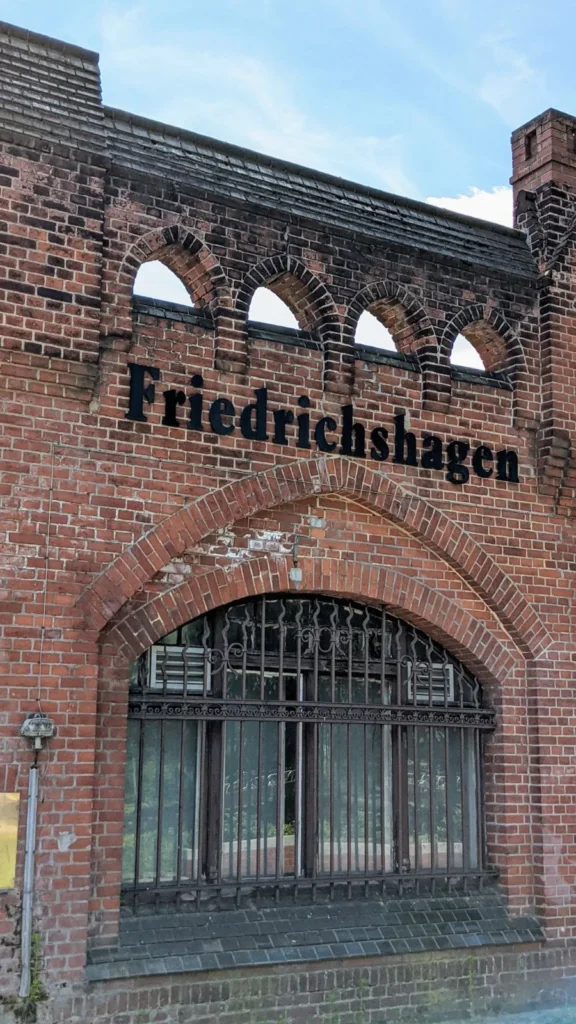 Bahnhof Friedrichshagen mit dem Schriftzug Friedrichshagen über dem Eingang, Backsteinfassade mit Rundbogenfenstern