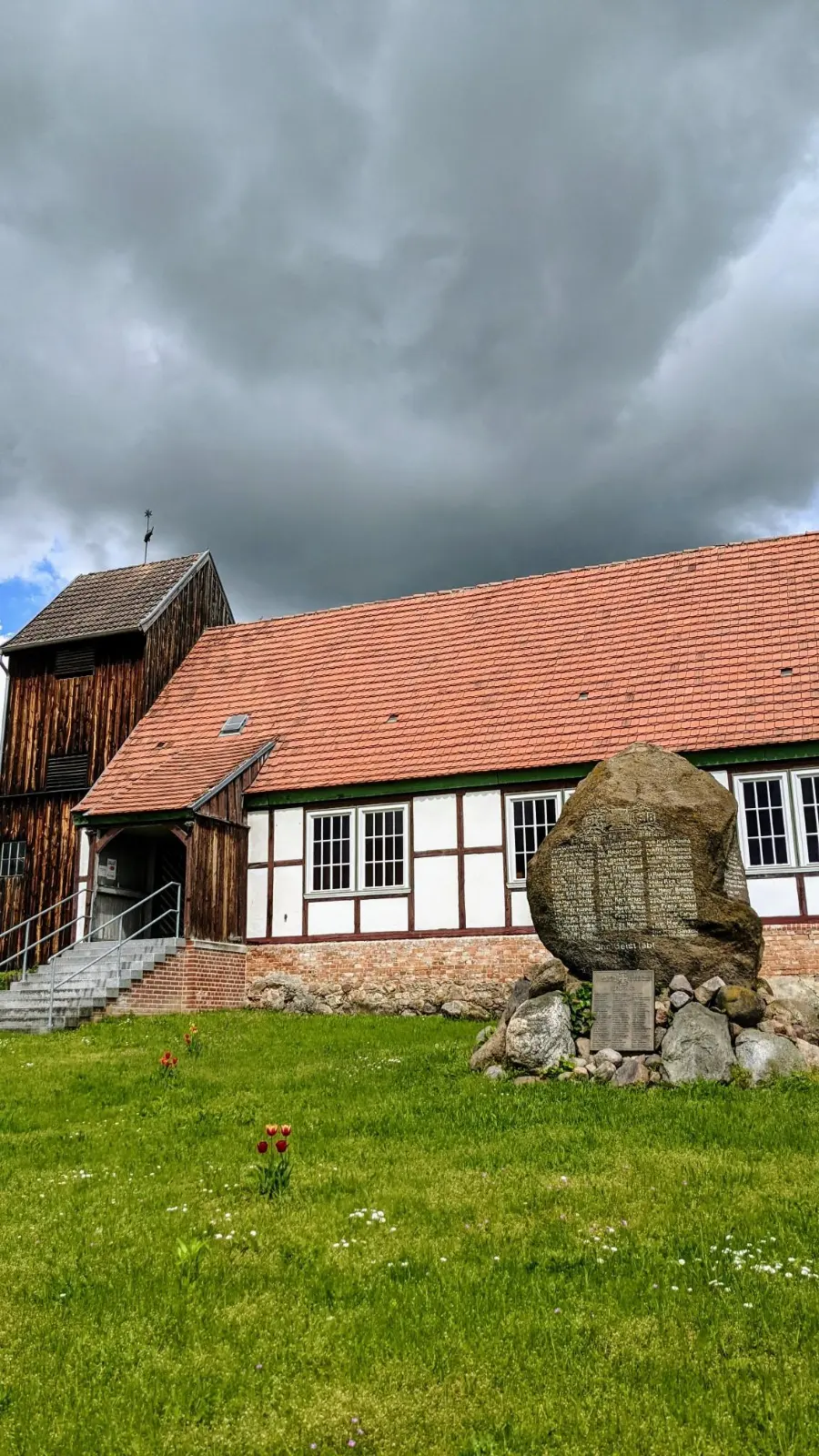 Fachwerkkirche in Liepe, davor das Kriegerdenkmal