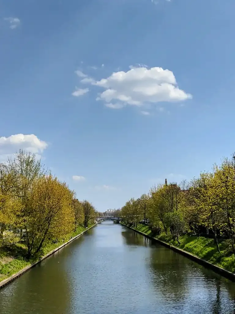 Neuköllner Schifffahrtskanal mit grünen Ufern, von einer Brücke gesehen