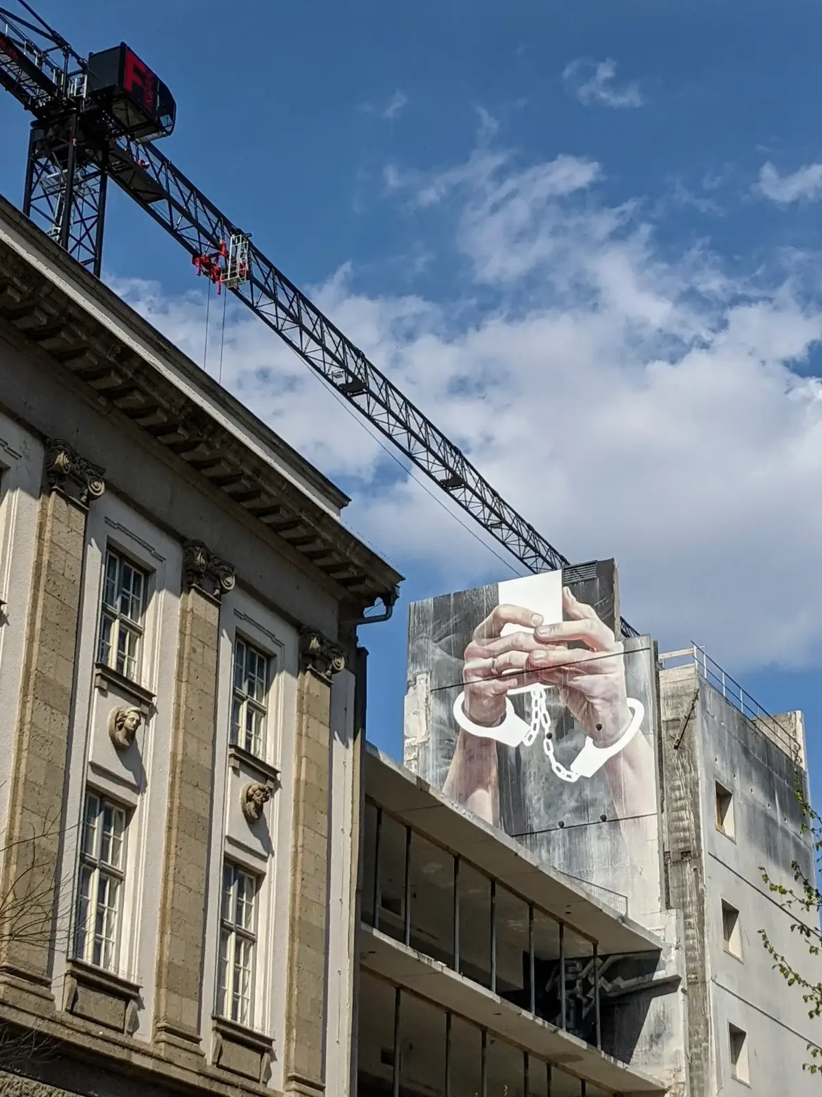 Wandbild Cell Phone von Innerfields an der Karl-Marx-Straße in Neukölln, daneben die Alte Post