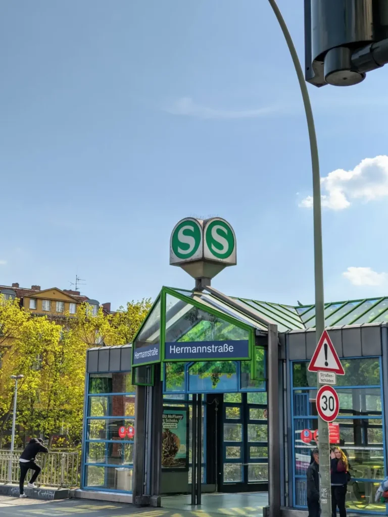 Grüner Glaspavillon am Eingang des S+U-Bahnhofs Hermannstraße