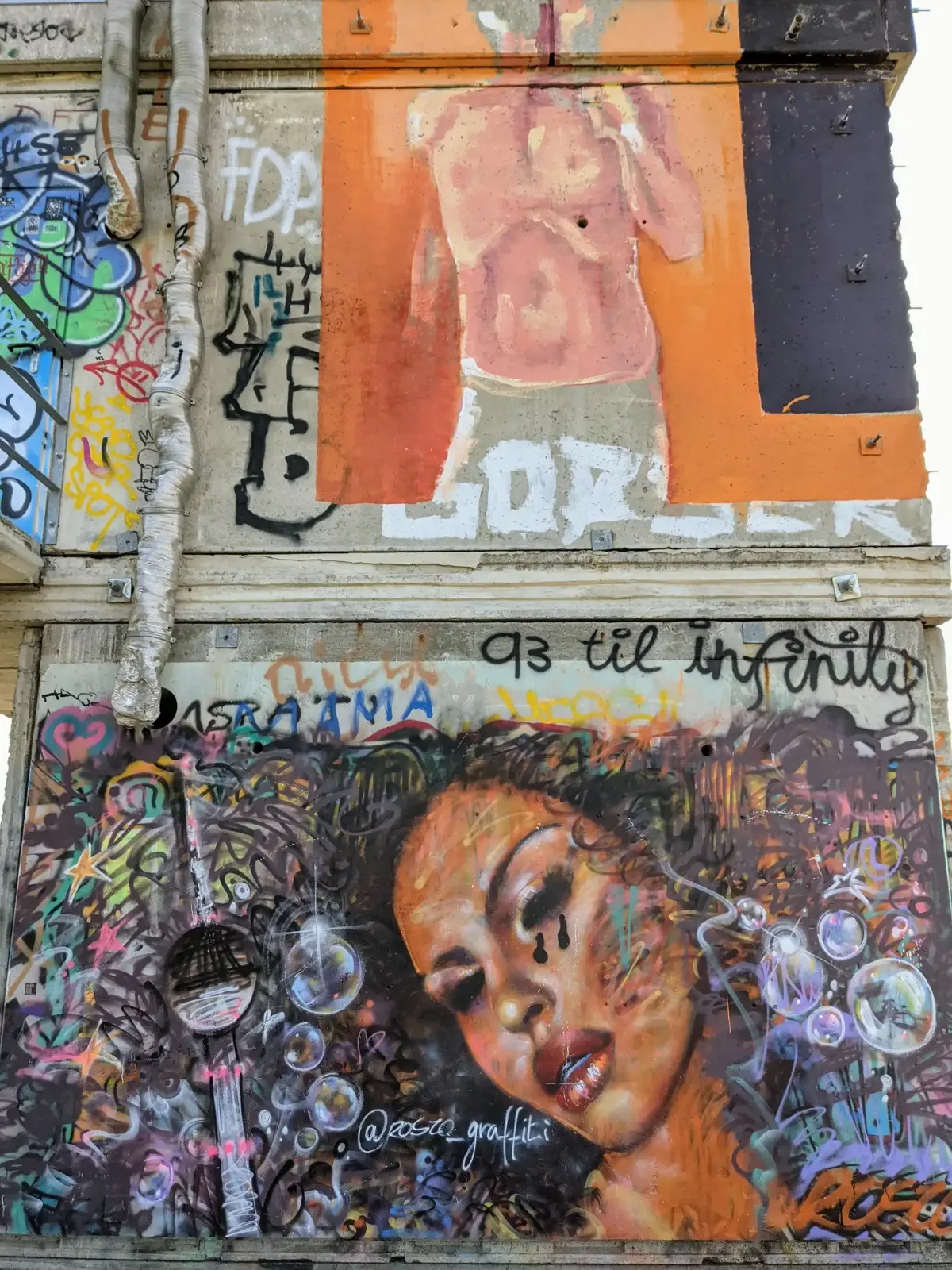 Graffiti mit Frauenporträt und Seifenblasen an einer Wand auf dem Tempelhofer Feld